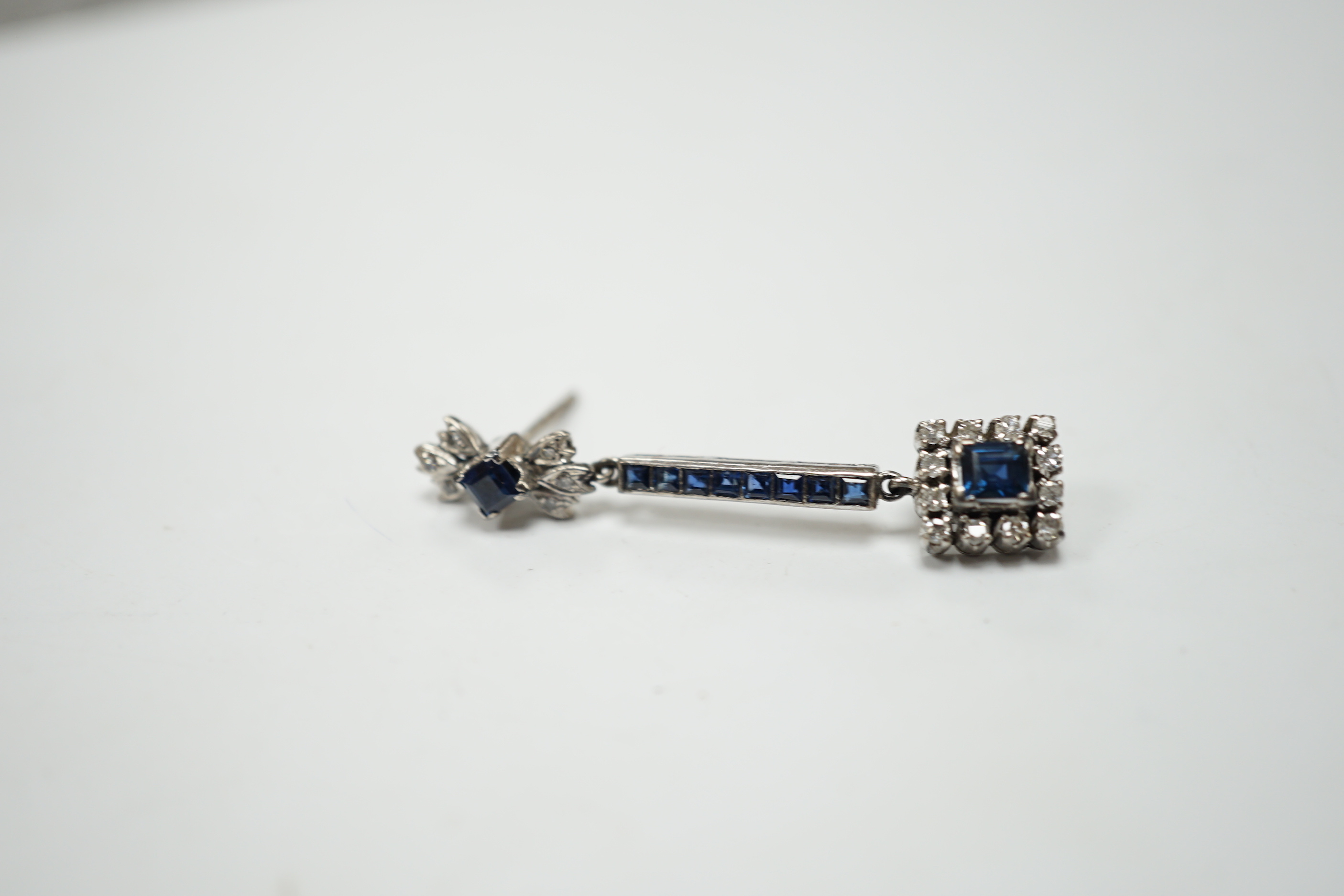 A single white metal (butterfly stamped 18), sapphire and diamond cluster set drop earring, 45mm, gross weight 4.1 grams.